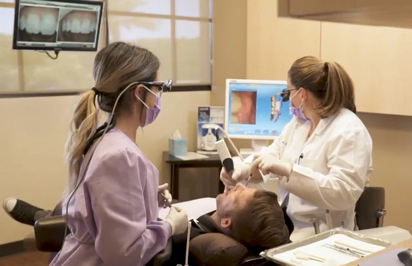 Dr. Reem Kidess performing dental procedure on patient