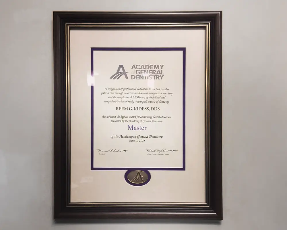 Framed Academy of General Dentistry certificate displayed on wall with black frame and cream matting.
